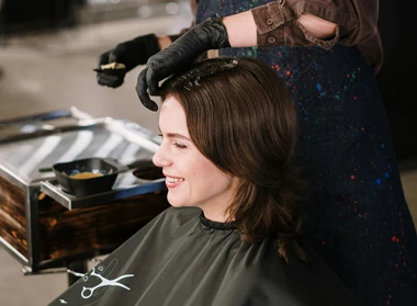 mujer cortandose el pelo en peluquera